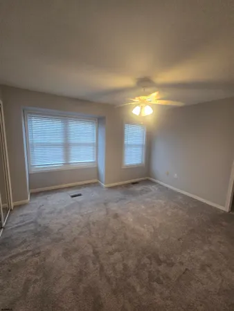 an empty room with windows and closet