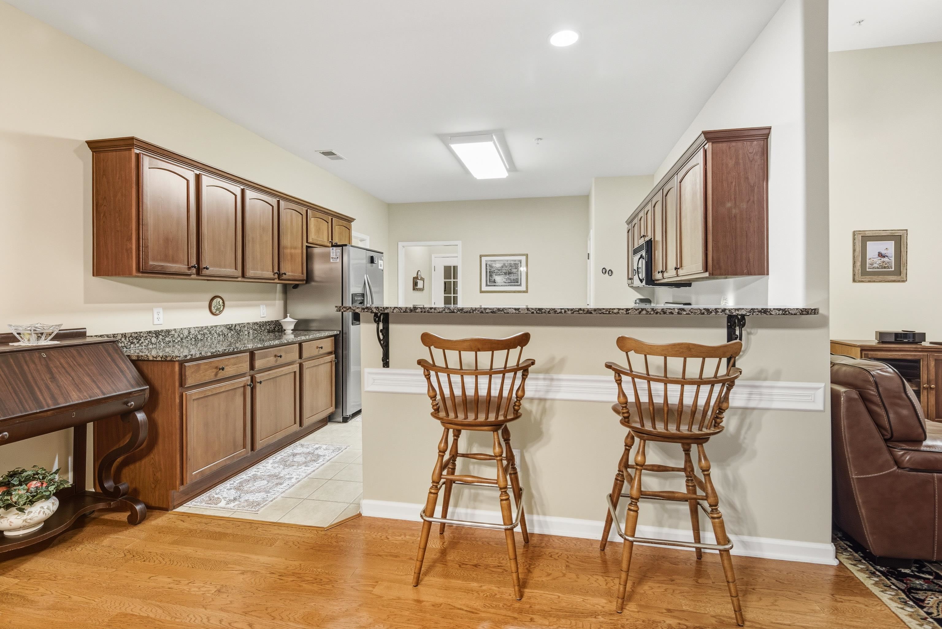 43 Peyton Ridge Drive, Unit 40 Collierville, TN 38017 - Photo 15 of 31 a kitchen with stainless steel appliances kitchen island granite countertop a dining table chairs and a refrigerator