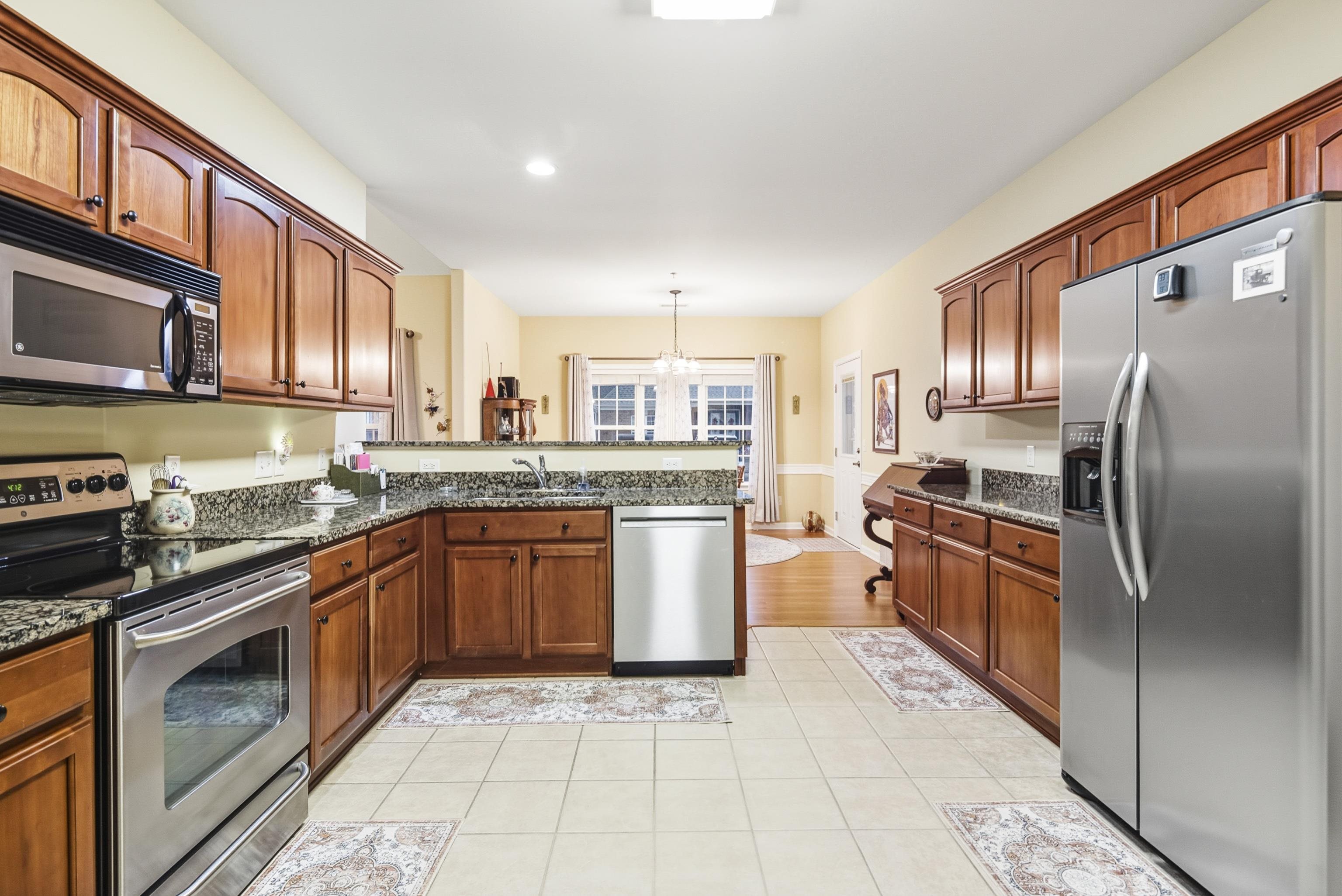 43 Peyton Ridge Drive, Unit 40 Collierville, TN 38017 - Photo 17 of 31 a kitchen with stainless steel appliances granite countertop a stove top oven a sink dishwasher a refrigerator and cabinets with wooden floor