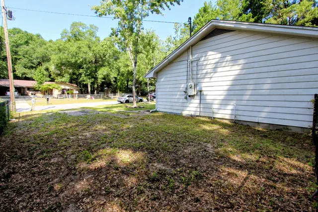 a view of backyard with small cabin and wooden fence