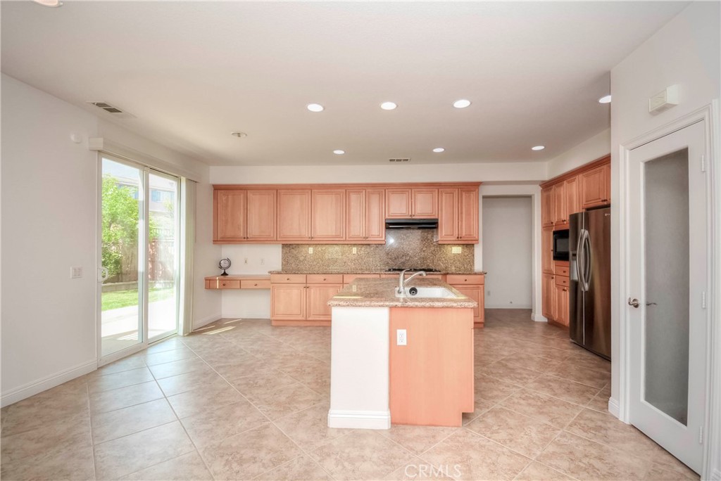 1803 Glen Rosa Street Upland, CA 91784 - Photo 12 of 68 a kitchen with stainless steel appliances kitchen island granite countertop a refrigerator and a sink