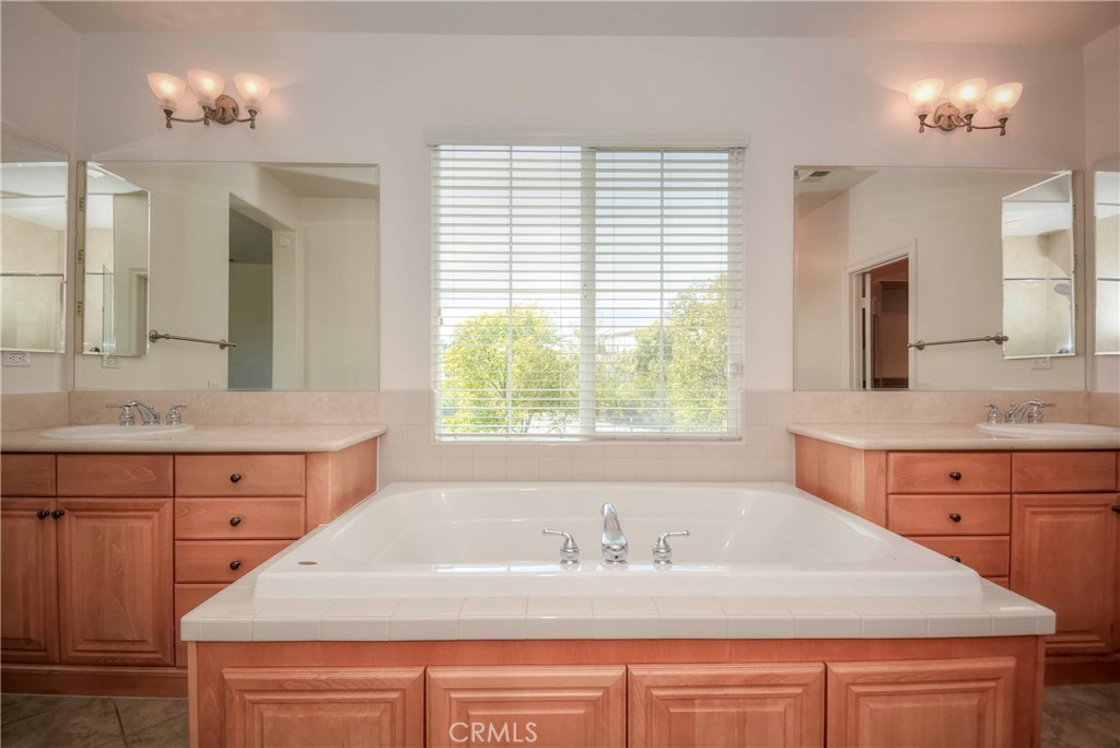 1803 Glen Rosa Street Upland, CA 91784 - Photo 40 of 68 a bathroom with a granite countertop sink a large mirror and a bathtub