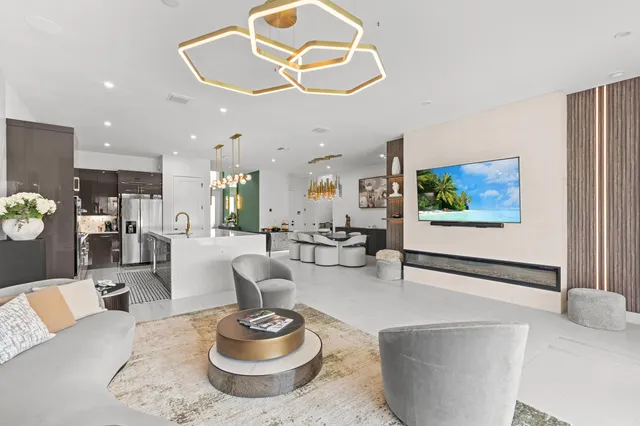 a living room with couches and kitchen view with wooden floor