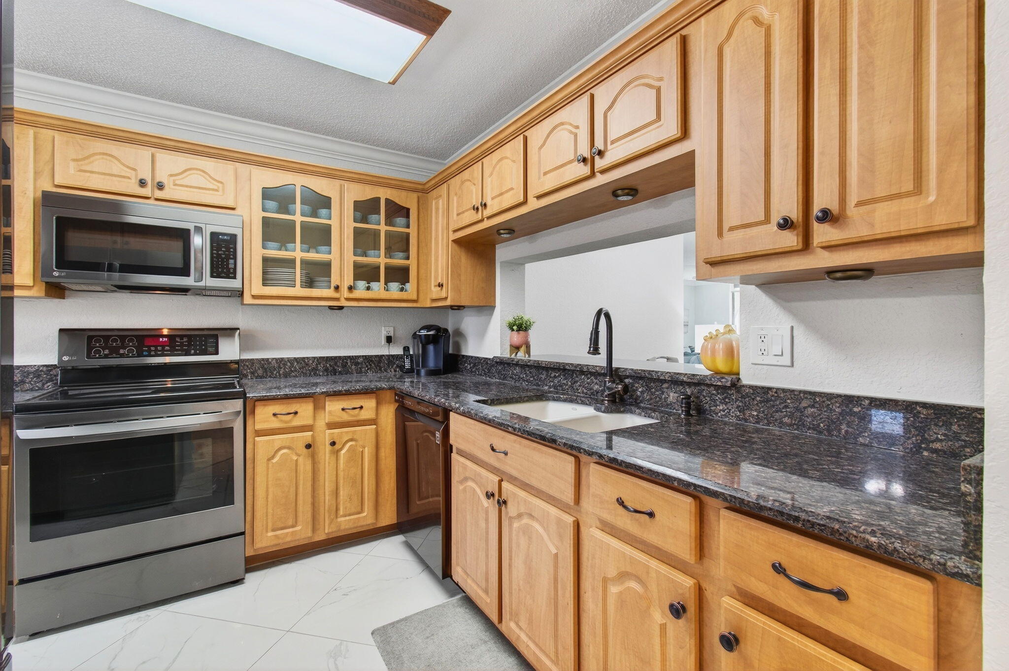 5574 Witney Drive, Unit 109 Delray Beach, FL 33484 - Photo 41 of 114 a kitchen with stainless steel appliances granite countertop a stove microwave and cabinets