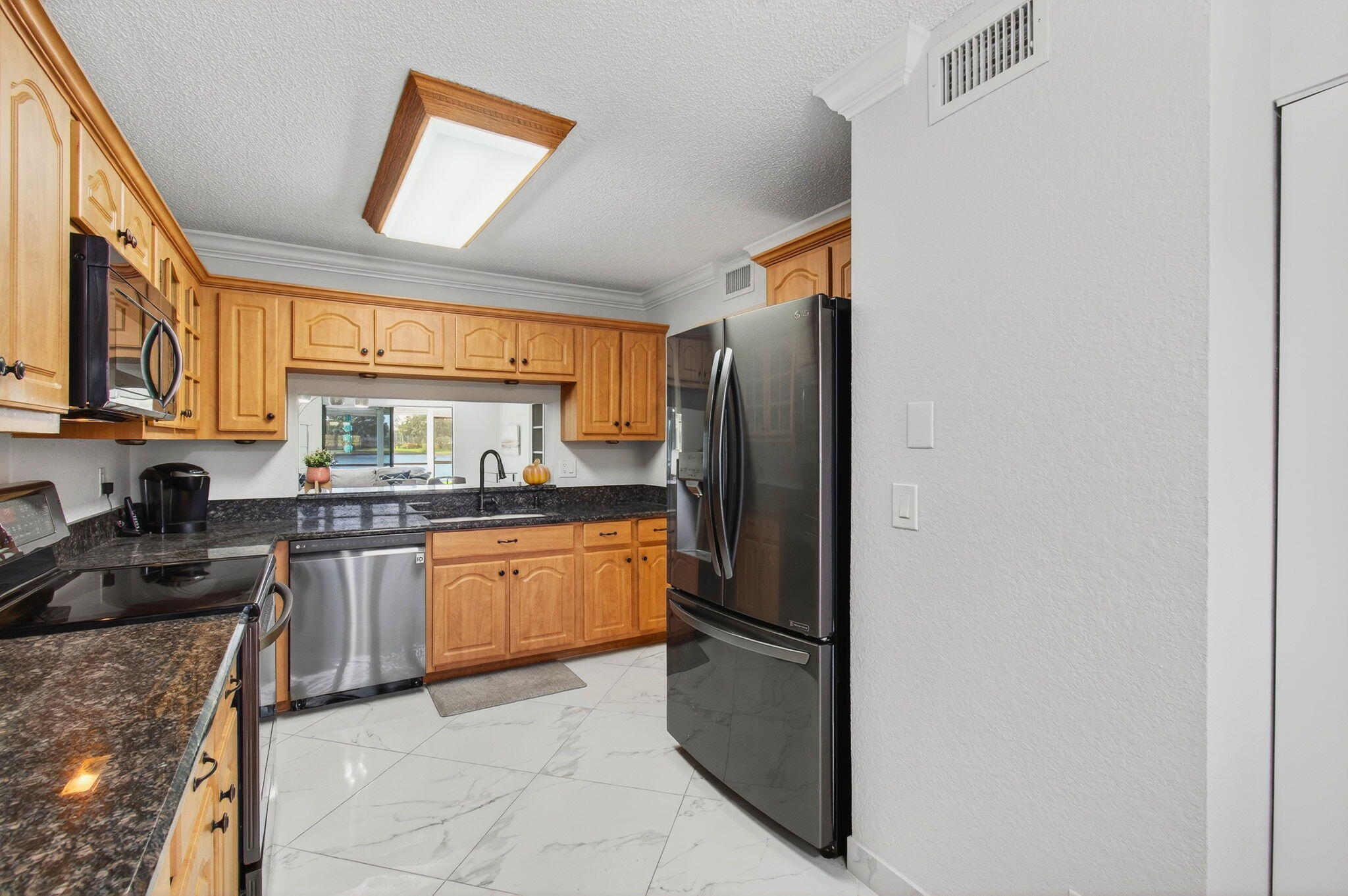 5574 Witney Drive, Unit 109 Delray Beach, FL 33484 - Photo 45 of 114 a kitchen with stainless steel appliances granite countertop a refrigerator and a stove top oven