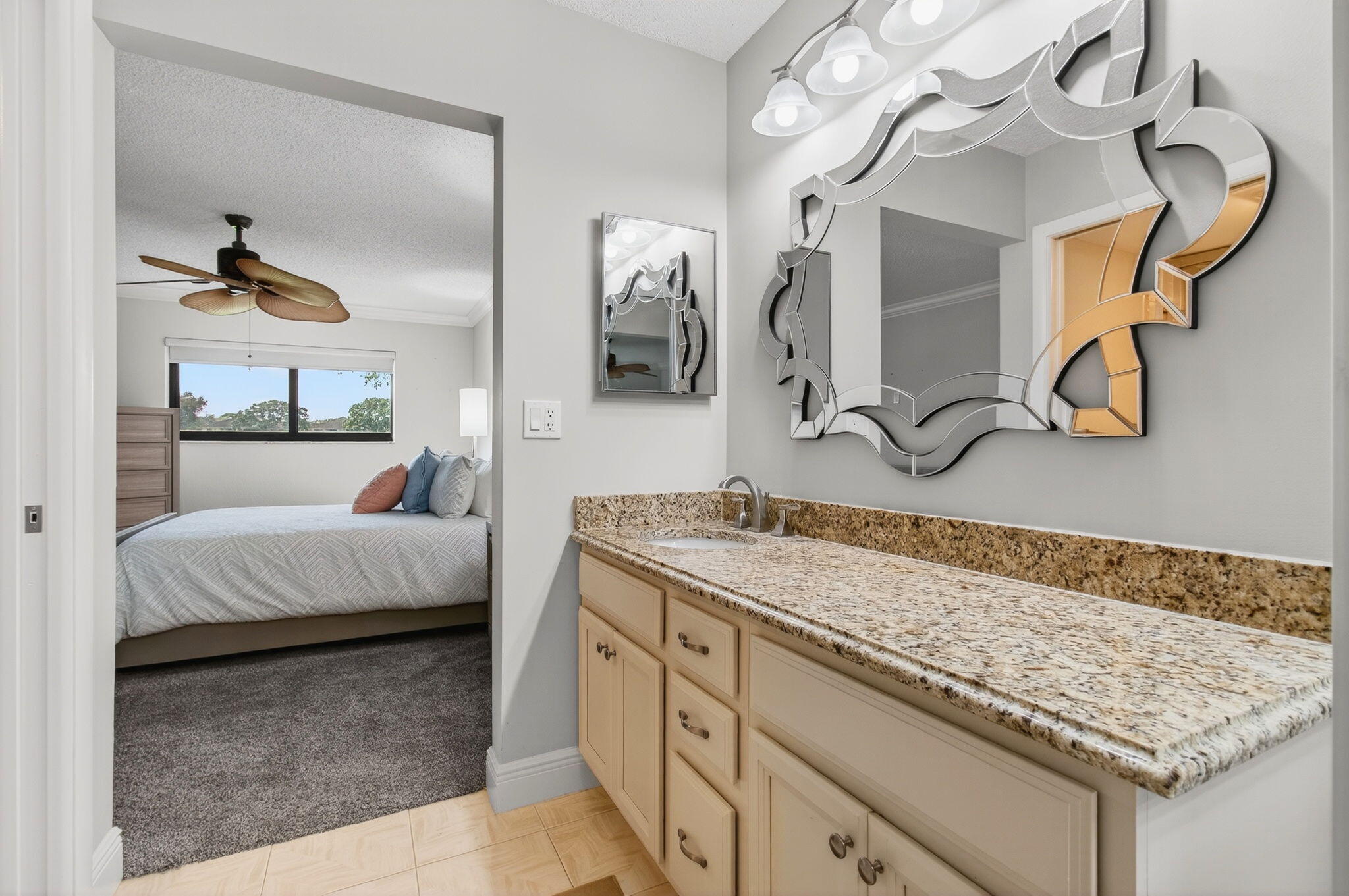 5574 Witney Drive, Unit 109 Delray Beach, FL 33484 - Photo 57 of 114 a en suite bathroom with a granite countertop sink and a mirror