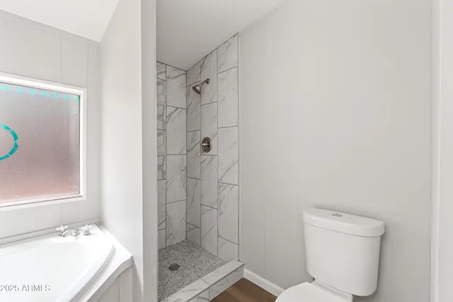 a bathroom with a double vanity sink a mirror and bathtub