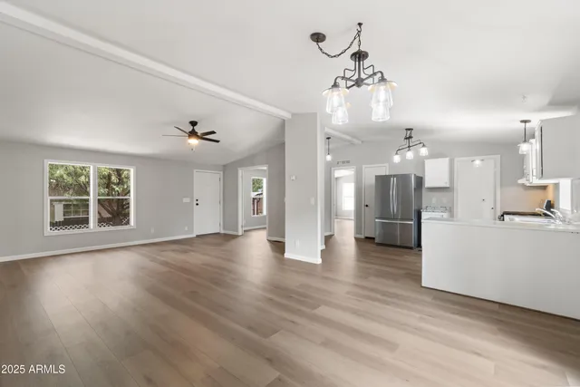 a view of empty room with wooden floor and ceiling fan