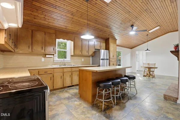 a kitchen with a stove a refrigerator and a table