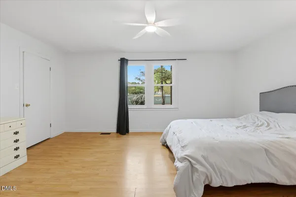 a bedroom with a bed and wooden floor