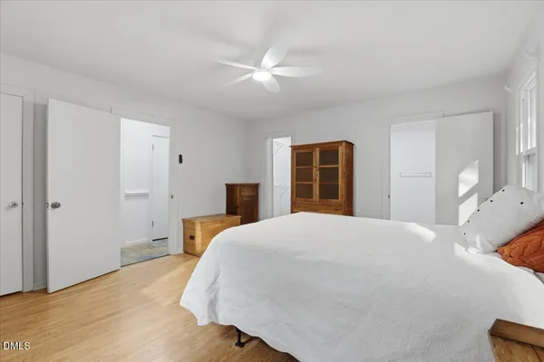a bedroom with a bed and wooden floor
