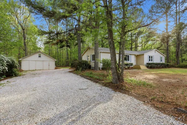 a view of a house with a yard and large tree