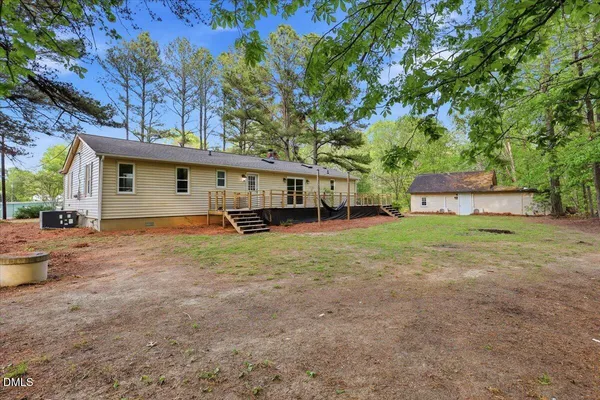 a view of a house with backyard and a tree