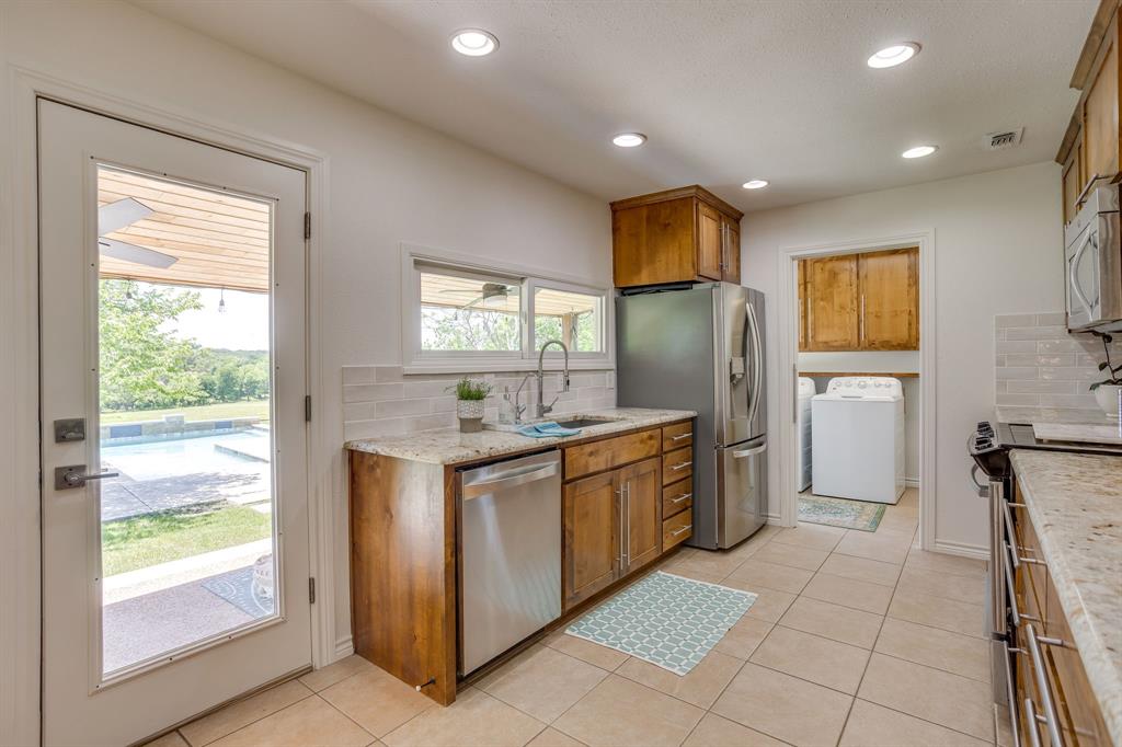 6345 Silver Creek Azle Road Azle, TX 76020 - Photo 18 of 40 a kitchen with stainless steel appliances granite countertop a refrigerator and a stove