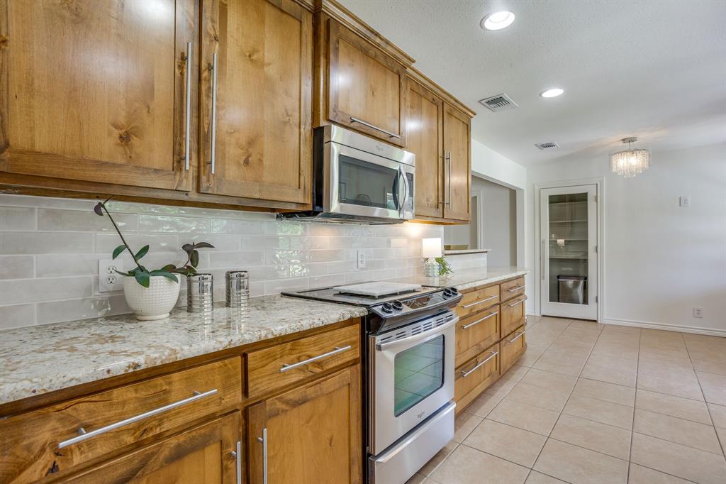 6345 Silver Creek Azle Road Azle, TX 76020 - Photo 19 of 40 a kitchen with stainless steel appliances granite countertop a stove a sink and a microwave