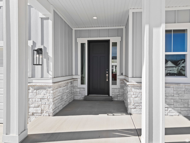 18 South Crimson Way, Unit 304 Mapleton, UT 84664 - Photo 3 of 17 View of exterior entry featuring covered porch, stone siding, and board and batten siding