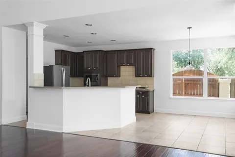 a kitchen with stainless steel appliances a refrigerator a sink a stove and white cabinets