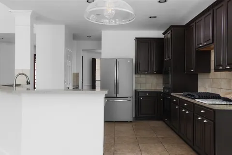 a kitchen with stainless steel appliances granite countertop a refrigerator a sink and a stove