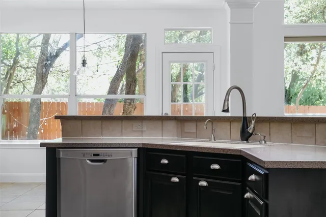 a kitchen with a sink a window and cabinets