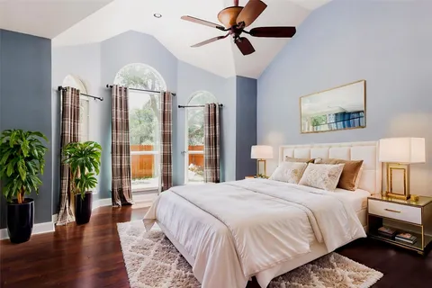 a bedroom with a bed a chandelier and potted plants with the outer view