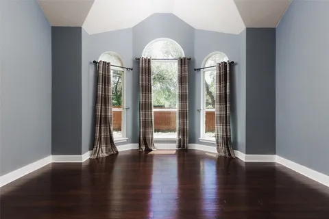 a view of a big room with wooden floor windows and plants