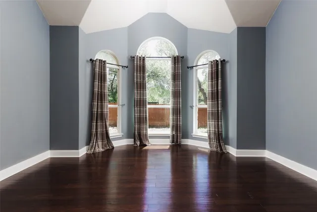 a view of a big room with wooden floor windows and plants