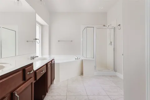 a spacious bathroom with a bathtub sink and mirror