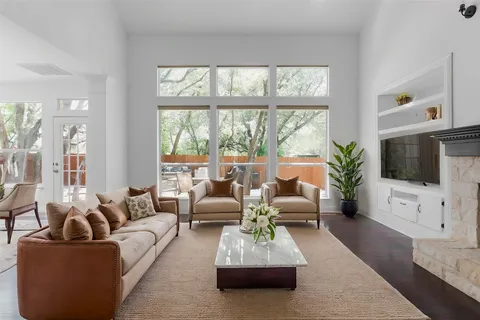 a living room with furniture a flat screen tv and a large window