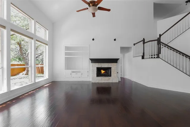 a view of an empty room with a fireplace and a window