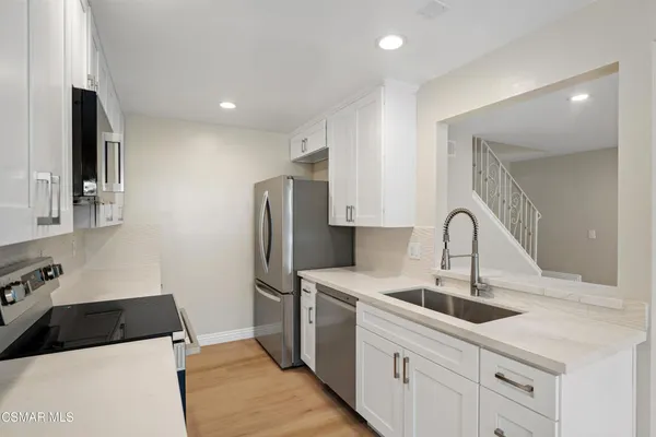a kitchen with a sink cabinets and wooden floor