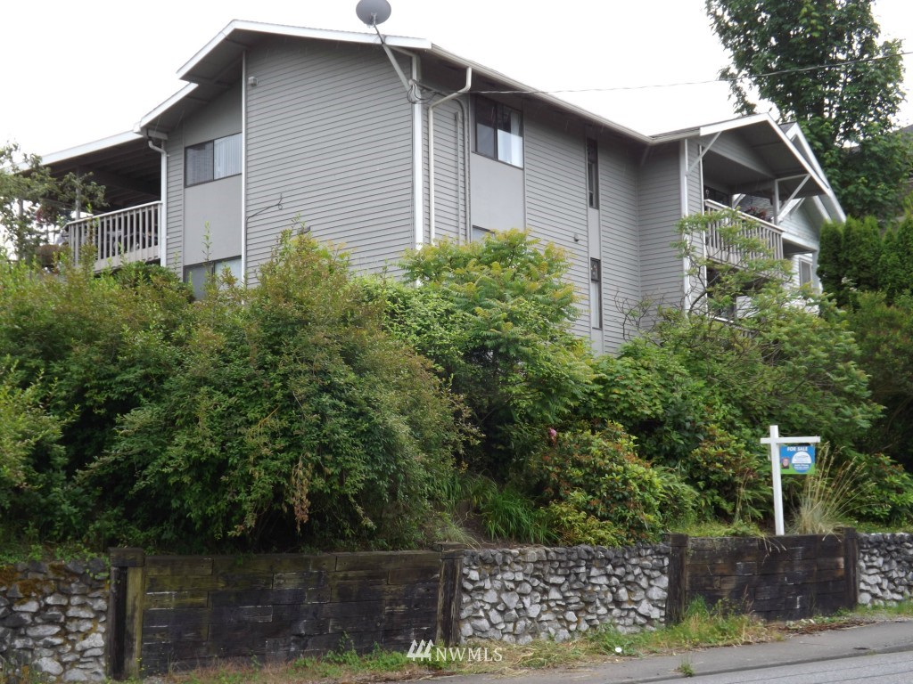 a front view of a house with plants and lake view