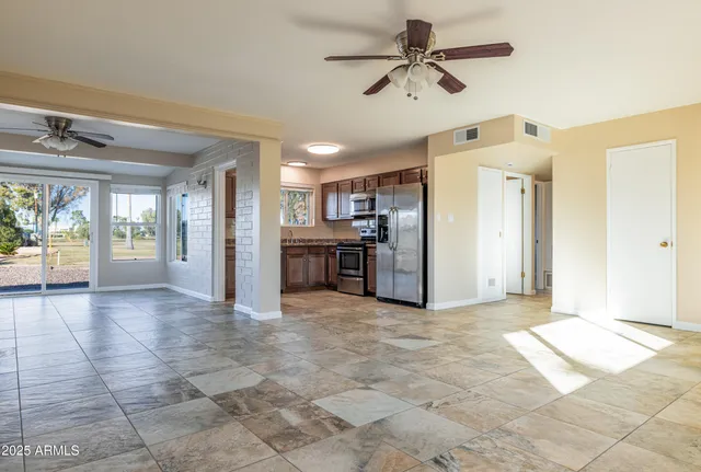 an empty room with a window and a fan