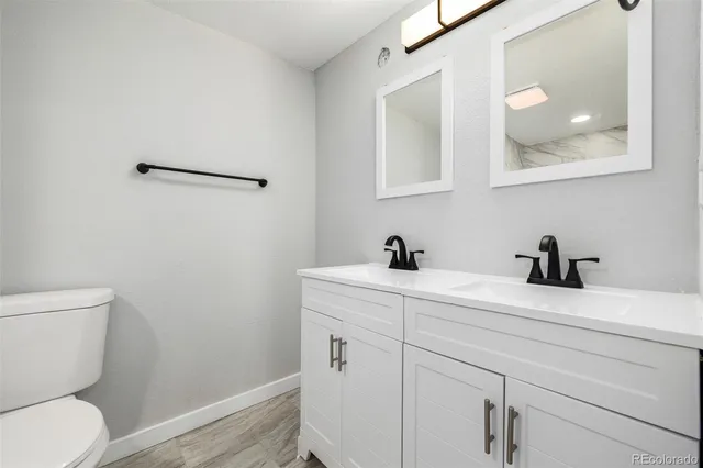 a bathroom with a toilet sink vanity and mirror