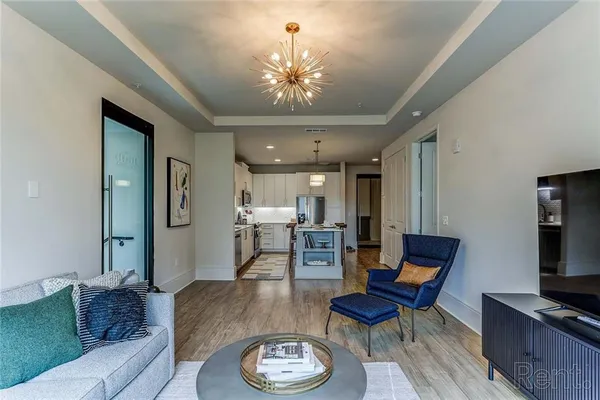 a living room with furniture a fireplace and a chandelier