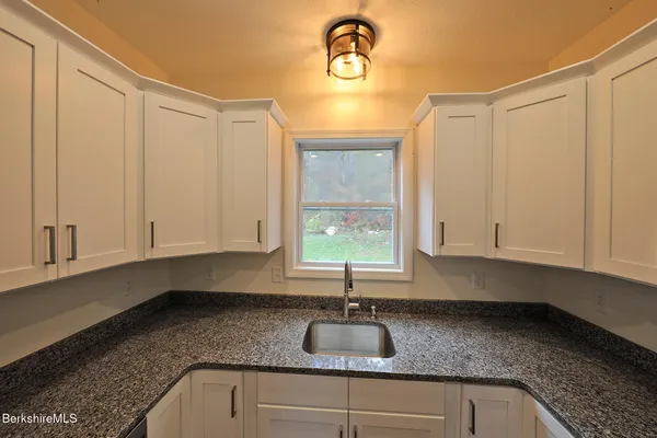 a view of a hallway with wooden floor and cabinet
