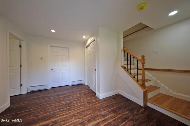 a kitchen with granite countertop a sink and white cabinets