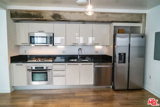 a kitchen with stainless steel appliances granite countertop a stove a sink and a microwave