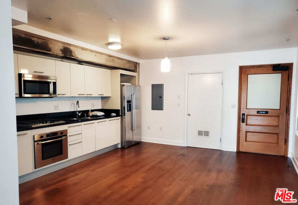 416 South Spring Street, Unit 906 Los Angeles, CA 90013 - Photo 15 of 18 a kitchen with granite countertop a stove and a refrigerator