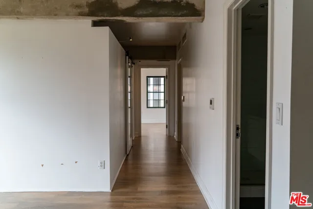 a view of a hallway with wooden floor