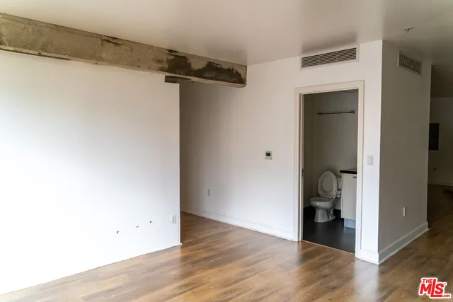 a view of walk in closet with wooden floor