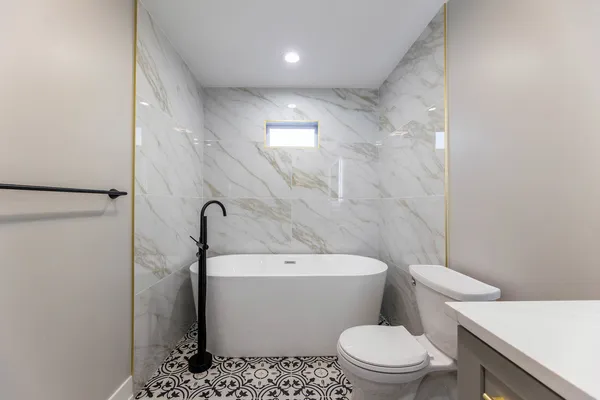 a white toilet sitting next to a bathroom sink and vanity