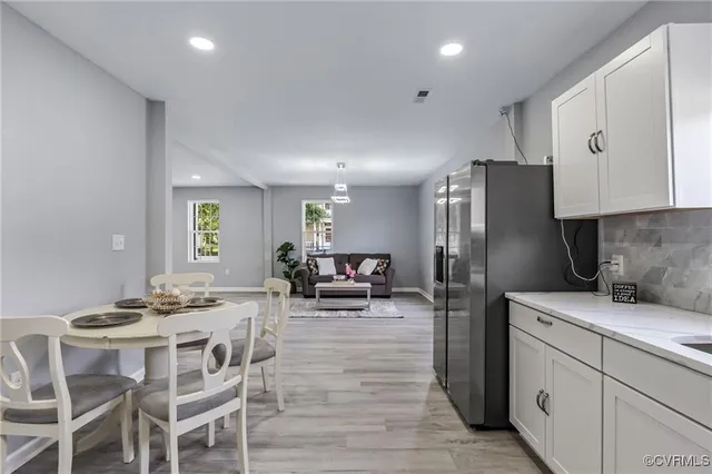 a kitchen with stainless steel appliances kitchen island granite countertop a sink refrigerator and cabinets