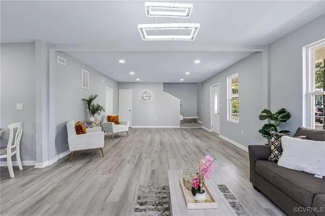 a living room with furniture and wooden floor