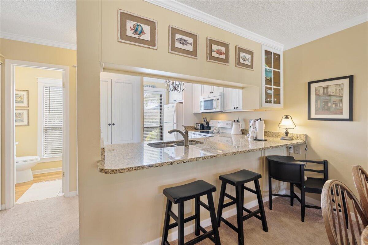 255 Pelican Circle, Unit 3 Inlet Beach, FL 32461 - Photo 11 of 38 a dining hall with stainless steel appliances granite countertop a dining table and chairs with wooden floor
