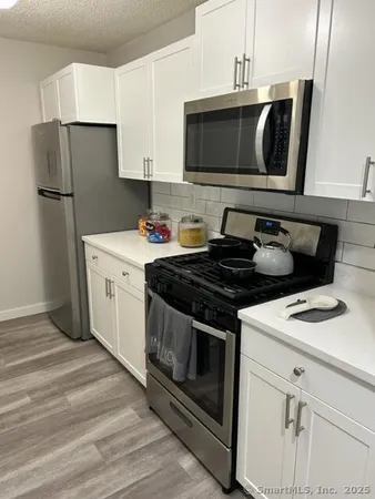 a kitchen with stainless steel appliances a stove microwave and refrigerator
