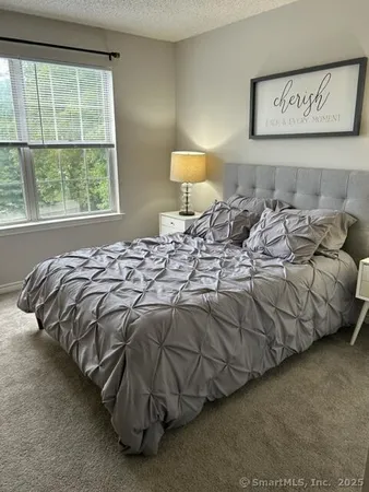 a bed sitting in a bedroom next to a window