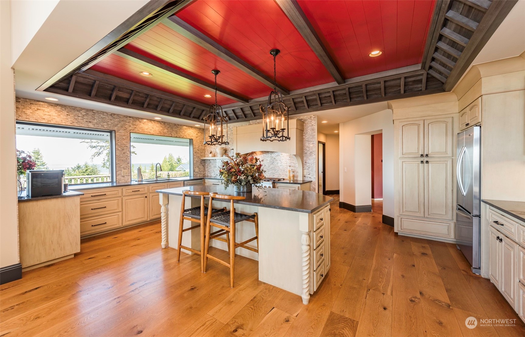 82 Owls Nest Road Sequim, WA 98382 - Photo 7 of 40 a kitchen with stainless steel appliances kitchen island granite countertop a stove a refrigerator a dining table and chairs with wooden floor