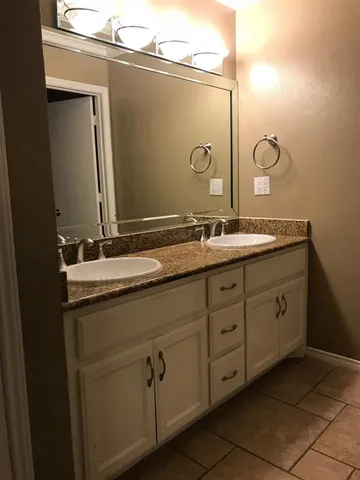 a bathroom with a double vanity sink and mirror