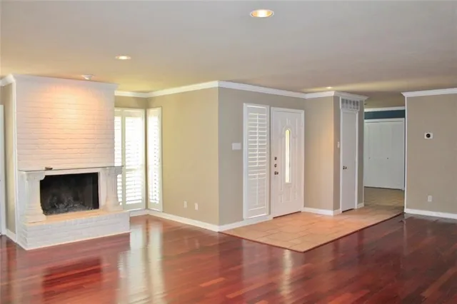 a view of a livingroom with wooden floor and a fireplace
