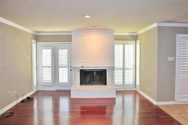 a view of a livingroom with wooden floor and a fireplace